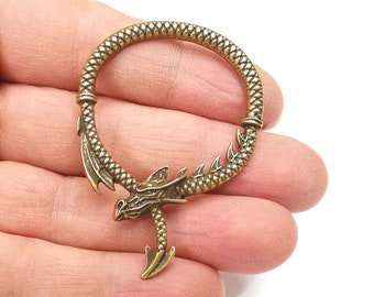 May include: A gold-toned dragon-shaped hoop earring with a textured, scaly design. The hoop is open and the dragon's head is facing forward.