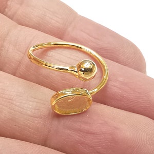 May include: Gold ring with a round ball and an oval shaped setting. The ring is open and can be adjusted to fit different finger sizes.