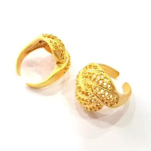 May include: Two gold rings with intricate, openwork designs. The rings are made of a delicate, filigree pattern and have a polished finish.