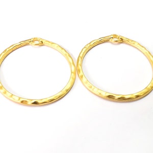 May include: A pair of gold-toned hoop earrings with a hammered texture.