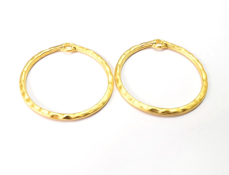 May include: A pair of gold-toned hoop earrings with a hammered texture.