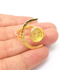 Op de afbeelding: Gouden halve maan ring met een ronde bezel setting. De ring is gemaakt van metaal en heeft een gehamerde textuur.
