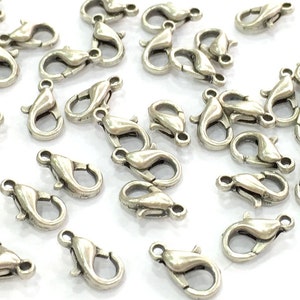 May include: A group of silver-toned lobster clasps, a type of fastener used in jewellery making.