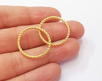 May include: Two gold-colored twisted wire rings. The rings are simple and delicate.