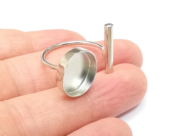 May include: Silver ring with a round bezel setting and a straight bar attached to the side.