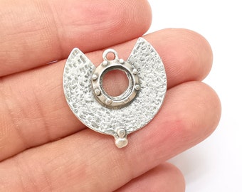 May include: Silver charm with a textured, half-moon shape and a round, open center. The charm has a small loop at the top for attaching to a necklace or bracelet.