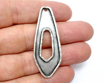 May include: A silver pendant with a textured, geometric design. The pendant has a large, open oval shape with a smaller, irregular shape cut out of the center.