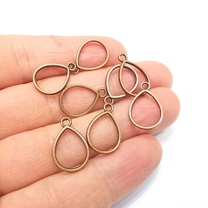Könnte beinhalten: Ein Set mit sechs antiken goldfarbenen Metall-Anhänger-Rohlingen in Tropfenform. Die Rohlinge haben eine glatte, polierte Oberfläche und sind bereit zum Basteln.