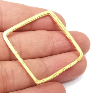 Könnte beinhalten: Goldfarbener quadratischer Metallrahmen mit gehämmerter Textur. Der Rahmen ist an allen Seiten offen.
