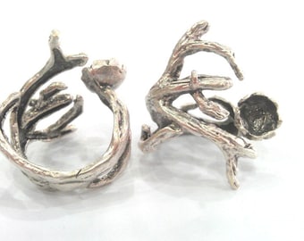 Puede incluir: Dos anillos de plata con un diseño único en forma de rama. Un anillo tiene una abertura redonda, mientras que el otro tiene un pequeño espacio redondo abierto.