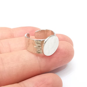 Könnte beinhalten: Silberner verstellbarer Ring mit einer runden, leeren Fassung zum Einsetzen eines Kameos oder anderer Verzierungen.