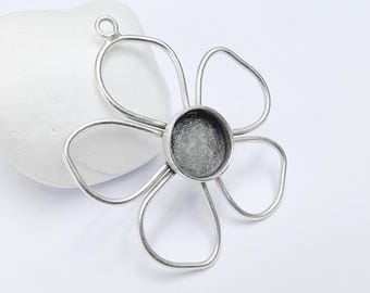 May include: A silver-toned metal flower-shaped pendant with a central circular setting. The pendant has six curved petals and a small loop at the top for a chain. The central setting is a dark gray color.