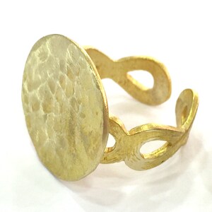 May include: A gold ring with a hammered, round, textured top and a delicate, openwork band.