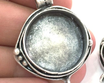 Op de afbeelding: Zilveren hanger met een ronde bezel-setting voor een cameo of andere versiering. De hanger heeft een decoratief ontwerp met een lus om een ketting aan te bevestigen.