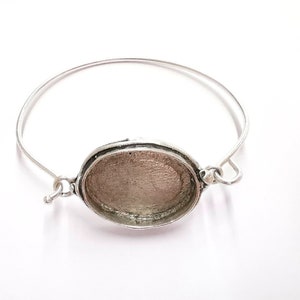 Op de afbeelding: Zilveren armband met een ovale bezel voor een cameo of andere versiering.