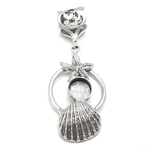 May include: Silver pendant featuring a seashell, a starfish, and a round bezel for a cameo or photo. The pendant is attached to a silver bail.
