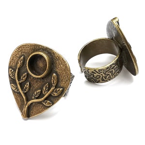 May include: Two bronze rings with a leaf design. One ring has a round, open space for a cameo or other embellishment.