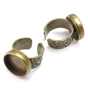 May include: Two adjustable ring blanks with a round bezel setting. The bezels are made of brass and have a vintage bronze finish. The rings are adjustable to fit most finger sizes.
