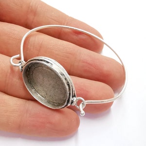 Op de afbeelding: Zilveren armband met een ronde, open bezel-setting. De bezel is ontworpen om een ronde cabochon of andere platte versiering te houden.