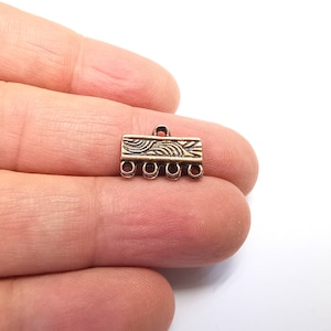 May include: A copper-toned metal connector with a decorative design and five loops for attaching jewelry or other crafts.