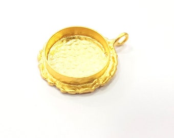 May include: Gold-toned metal pendant with a round, scalloped edge and a smooth, circular opening. The pendant has a loop at the top for attaching to a chain or cord.