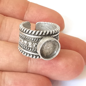 Puede incluir: Anillo de plata con un engaste redondo para una piedra cabuj&oacute;n. El anillo tiene un dise&ntilde;o texturizado con acentos de cuerda y cuentas.