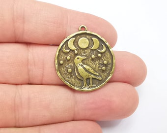 Op de afbeelding: Een gouden metalen bedel met een gestileerde raaf met een halve maan en sterrenontwerp.