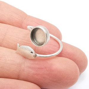 May include: Silver ring with a fish design and a round bezel for a cameo or other embellishment.