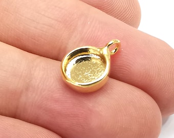 May include: Gold-toned pendant with a round, flat, open-backed tray for adding a small embellishment. The pendant has a loop at the top for attaching to a chain or cord.