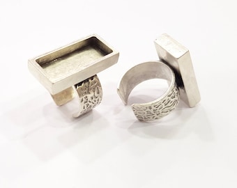 May include: Two silver rings with a rectangular bezel setting. The bezels are empty and ready to be filled with resin or other materials.