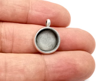 Puede incluir: Pendiente de plata con un cabujón redondo de vidrio transparente. El pendiente está diseñado para agregar una imagen o diseño personalizado.
