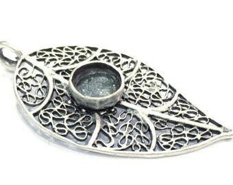Puede incluir: Pendiente de hoja de filigrana de plata con un bisel redondo para una piedra o cabujón.