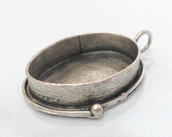 May include: Silver oval pendant setting with a textured rim and a loop for attaching a chain.