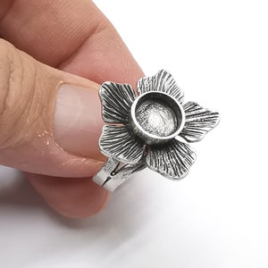 Op de afbeelding: Zilveren bloemenring met een ronde, open bezel om een cabochon of andere versiering toe te voegen.