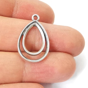 Puede incluir: Pendiente de plata con un diseño de doble bucle en forma de lágrima.