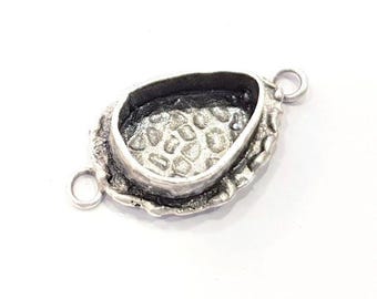 May include: Silver-toned pendant with a textured oval-shaped bezel, designed to hold a stone or other embellishment. The pendant has two jump rings for attaching to a chain or other jewelry.