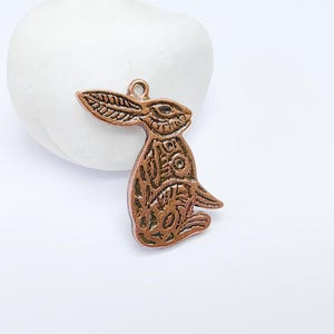 May include: A copper-colored rabbit charm with intricate details, perfect for adding a touch of whimsy to jewelry or crafts.