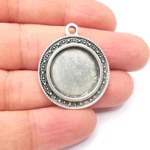 Op de afbeelding: Zilveren hanger met een rond, versierd frame en een leeg middenstuk om een cameo of andere versiering toe te voegen.