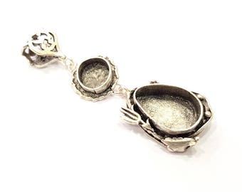 May include: Silver pendant with two open circular settings and a larger oval setting. The pendant is detailed with intricate designs.