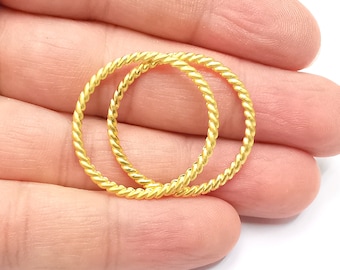 May include: Two gold-colored, twisted wire hoop earrings.