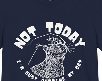 May include: Navy blue t-shirt with the text "NOT TODAY I'M BUSY PETTING MY CAT" in white. The graphic features a cat being petted. The shirt has short sleeves and a crew neck.