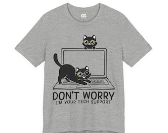 May include: A heather gray t-shirt featuring a playful graphic of two black cats with glasses and a laptop. The text "DON'T WORRY I'M YOUR TECH SUPPORT" is printed below the laptop. The shirt has a crew neck and short sleeves.