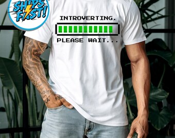 Camiseta "Por favor, espera" con humor introvertido, texto minimalista, cuello redondo unisex de algodón suave, ropa informal para uso diario.