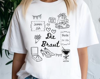 Puede incluir: Camiseta blanca con un diseño gráfico negro con ilustraciones temáticas de boda. El diseño incluye un pastel, zapatos, un joyero y el texto "Die Braut" y "Berlin Est. 2026".