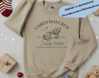 May include: A beige crewneck sweatshirt featuring a dark green graphic of a vintage truck carrying a Christmas tree. The text reads CHRISTMAS CREW, EST 2026, Family Müller, and MAKING MEMORIES TOGETHER, accompanied by small snowflake icons.