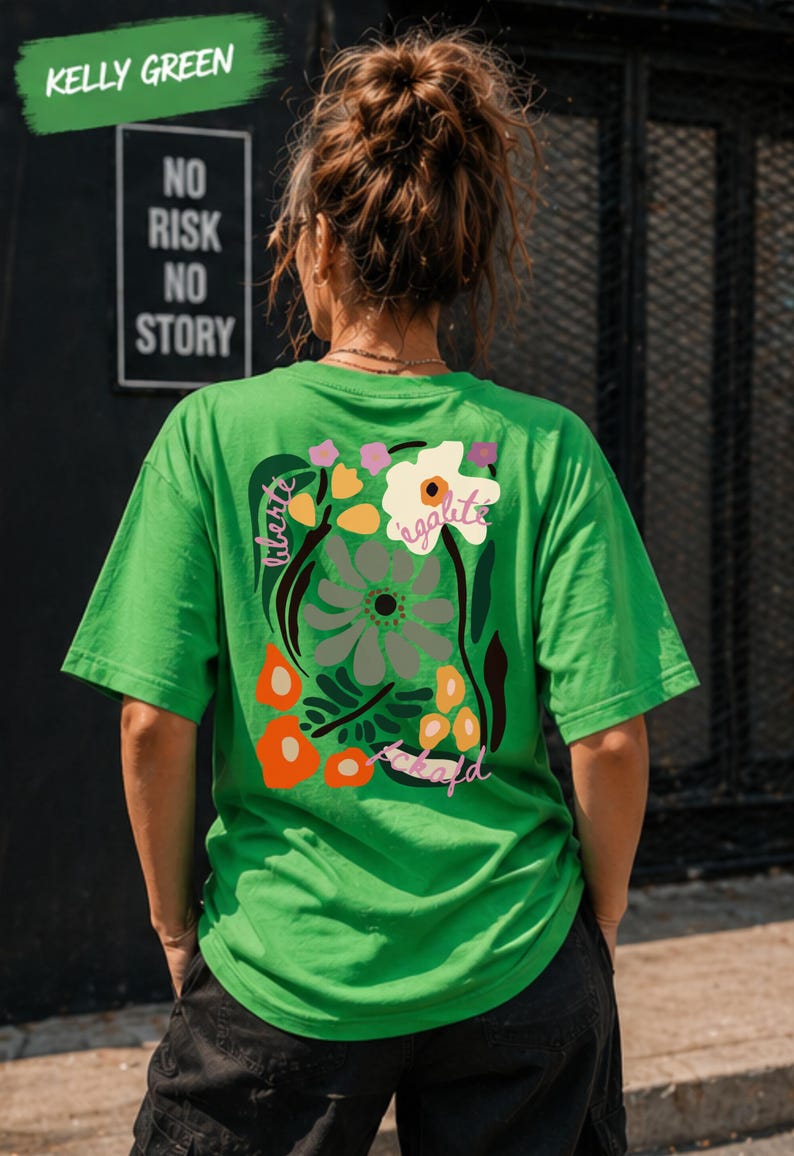 Puede incluir: Camiseta verde Kelly con un dise&ntilde;o floral en la espalda, con las palabras "liberte" y "egalite". La camiseta tambi&eacute;n tiene las palabras "fckafd" en una fuente de escritura. Las palabras "Kelly Green" est&aacute;n en una pancarta verde en la parte superior.
