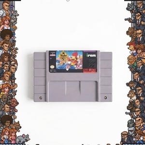 May include: A gray Super Nintendo video game cartridge featuring a label with the title Rocky Rodent, a character with red hair, and the Irem logo. The cartridge is surrounded by a pixel art border of various characters and city elements.