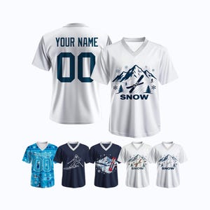 Könnte beinhalten: Weiße V-Ausschnitt-T-Shirts mit Wintermotiven. Eines zeigt eine Berglandschaft mit Skiern und dem Wort „SNOW“. Ein anderes hat „YOUR NAME“ und die Nummer „00“. Zusätzliche Shirts mit Ski- und Bergdesigns sind ebenfalls abgebildet.