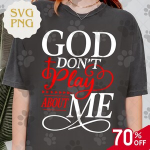 May include: Dark gray t-shirt with the text "GOD DON'T PLAY ABOUT ME" in white and red. The shirt has a round neckline and short sleeves. A 70% off sale tag is visible in the bottom right corner.