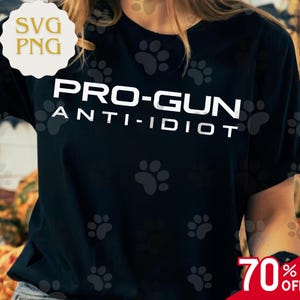 May include: Black t-shirt featuring the white text "PRO-GUN ANTI-IDIOT". The shirt has paw print graphics and a "SVG PNG" logo in the upper left corner. A red "70% OFF" sticker is in the lower right corner.
